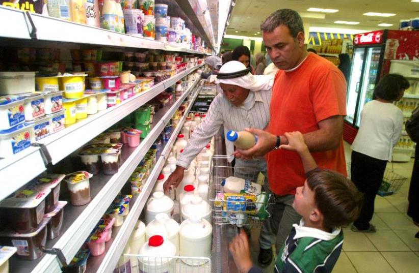 Shoppers buy Israeli food products at a Ramallah supermarket in 2003 (photo credit: JAMAL ARURI / AFP)