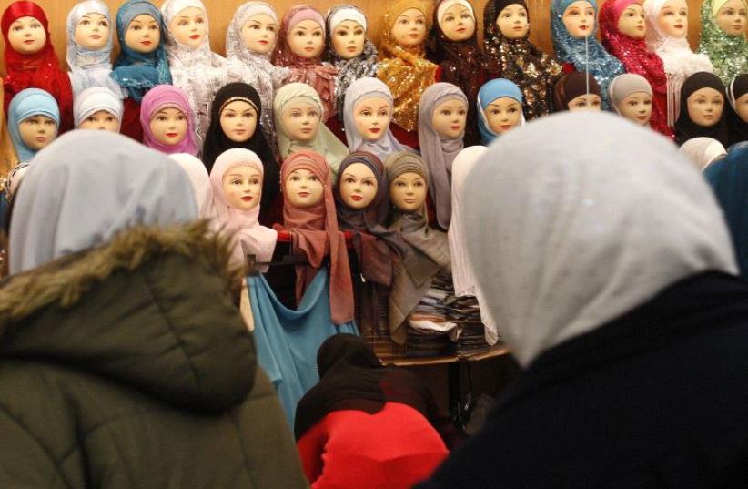 Women look at headgear of Muslim women inside an exhibition hall s at Le Bourget (photo credit: REUTERS)