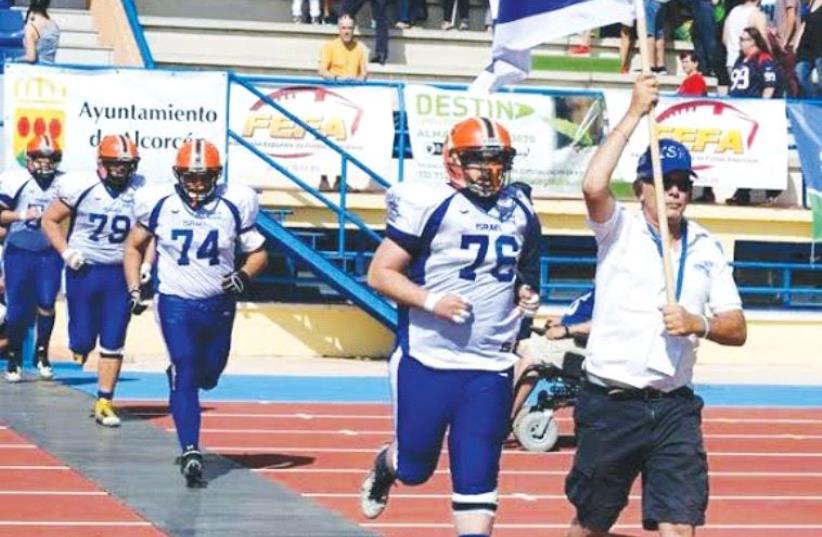 AMERICAN FOOTBALL IN ISRAEL president Steve Leibowitz leads the national tackle football team onto the field to face Spain in its only previous international match before this weekend’s European Championship qualifying tournament in Italy. (photo credit: AFI COURTESY)