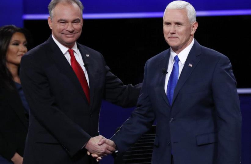 Democratic US vice presidential nominee Senator Tim Kaine shakes hands with Republican US vice presidential nominee Governor Mike Pence (R) (photo credit: REUTERS)