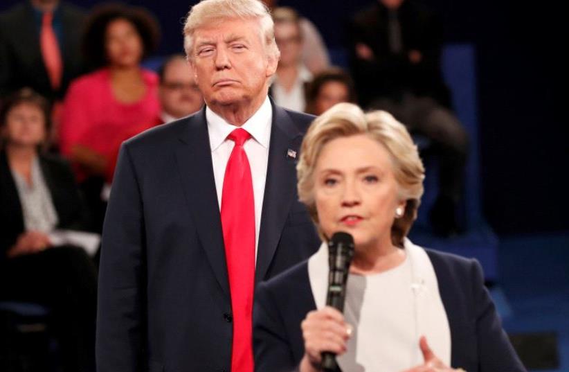 Republican US presidential nominee Donald Trump listens as Democratic nominee Hillary Clinton answers a question from the audience during their presidential town hall debate at Washington University in St. Louis, Missouri, US, October 9, 2016 (photo credit: REUTERS)