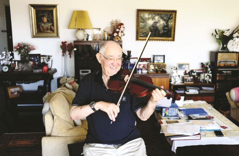 Yonatan Rosen joue sur le violon de sonpère Moshe Rosenzweig, auteur de ces partitions composées en 1945 (photo credit: YAD VASHEM)