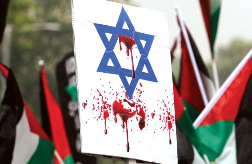 AN ISRAELI FLAG stained with fake blood at a pro-Palestinian rally in London. (photo credit: REUTERS)