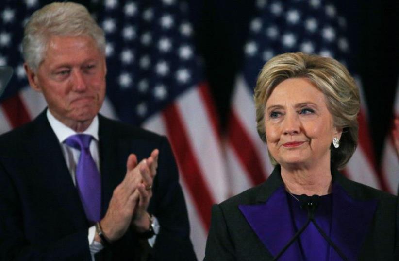 Hillary Clinton, accompanied by her husband former US President Bill Clinton (L), addresses her staff and supporters about the results of the US election. (photo credit: REUTERS)