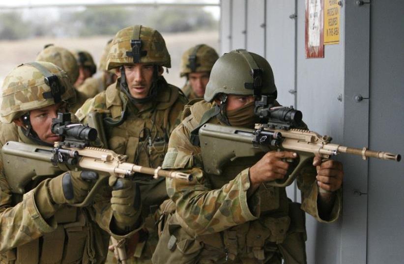 Soldiers of Alpha Company 1RAR of the Australian Army get ready to clear a building during training for the multi-national military exercise RIMPAC at Pohakuloa Training Area on the island of Hawaii July 22, 2012 (photo credit: REUTERS)
