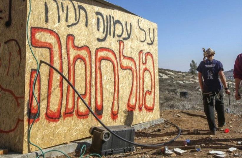 ‘THERE WILL be war over Amona,’ the graffiti reads at the outpost in the Binyamin region of Samaria in the West Bank (photo credit: MARC ISRAEL SELLEM/THE JERUSALEM POST)