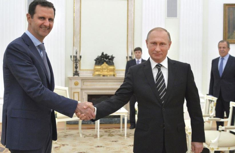 RUSSIAN PRESIDENT Vladimir Putin (right) shakes hands with Syrian President Bashar Assad during a meeting at the Kremlin in Moscow in 2015. (photo credit: REUTERS)