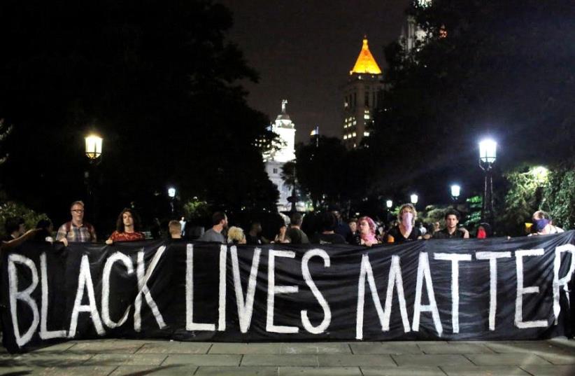 People hold up a banner during a Black Lives Matter protest outside City Hall in Manhattan, New York (photo credit: REUTERS)