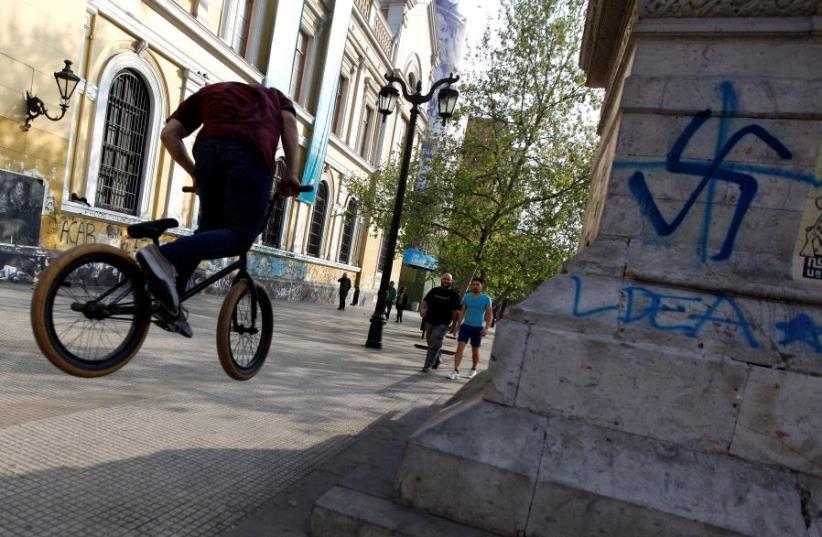 What appears to be a swastika spray-painted on a wall of the University of Chile in downtown Santiago [File] (photo credit: REUTERS)