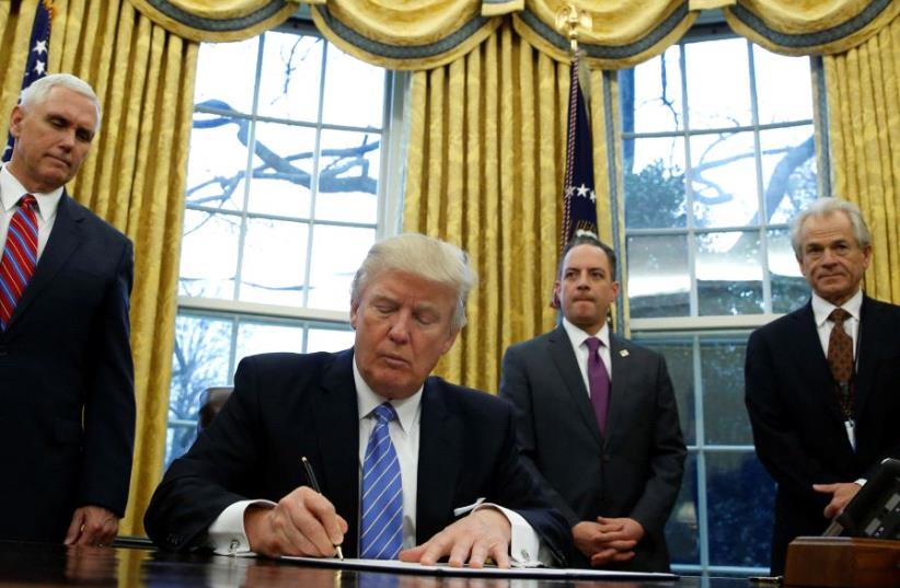 US President Donald Trump signs an executive order in the Oval Office of the White House (photo credit: REUTERS)