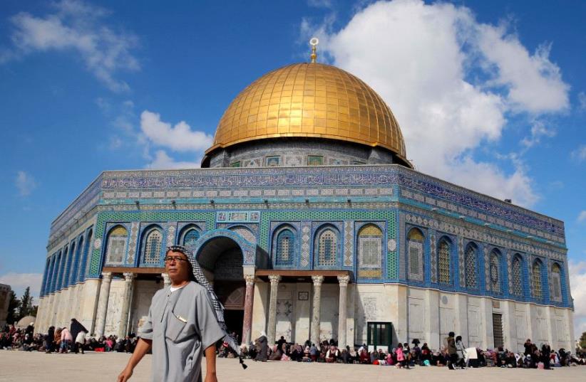 A man walks next to the Dome of the Rock on the Temple Mount compound  (photo credit: REUTERS)