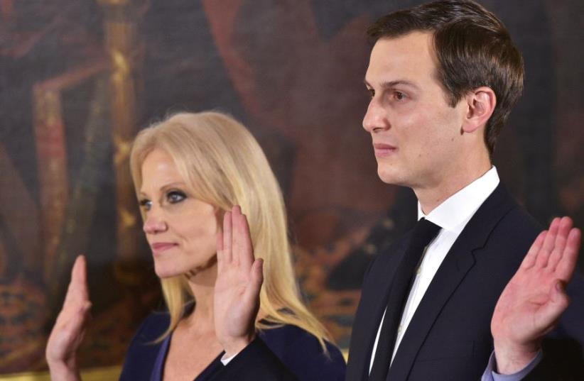 Counselor to the President Kelleyanne Conway (L) and Senior Advisor to the President Jared Kushner raise their hands during the swearing-in of senior staff in the East Room of the White House on January 22, 2017 in Washington, DC (photo credit: MANDEL NGAN/AFP)