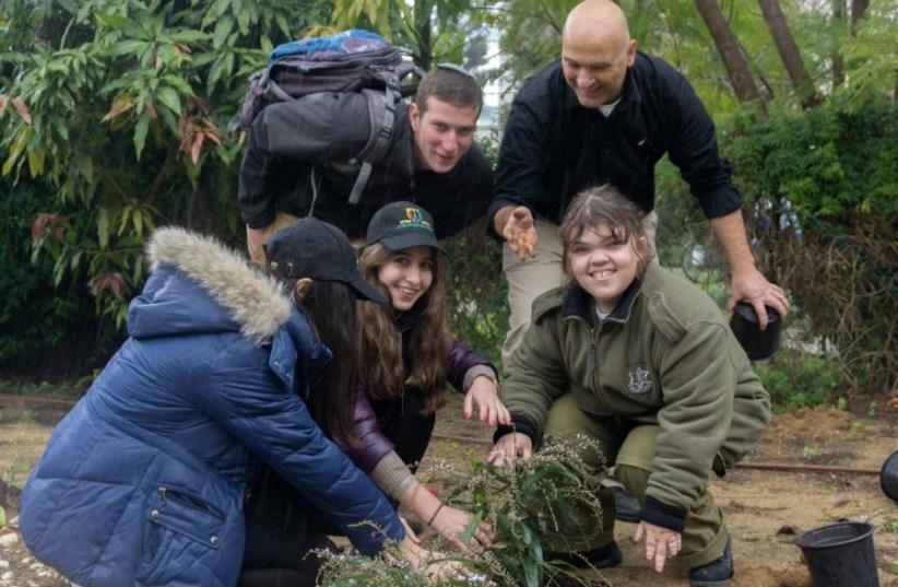 Special in Uniform participants and volunteers plant a tree in honor of Tu Bishvat  (photo credit: Courtesy)