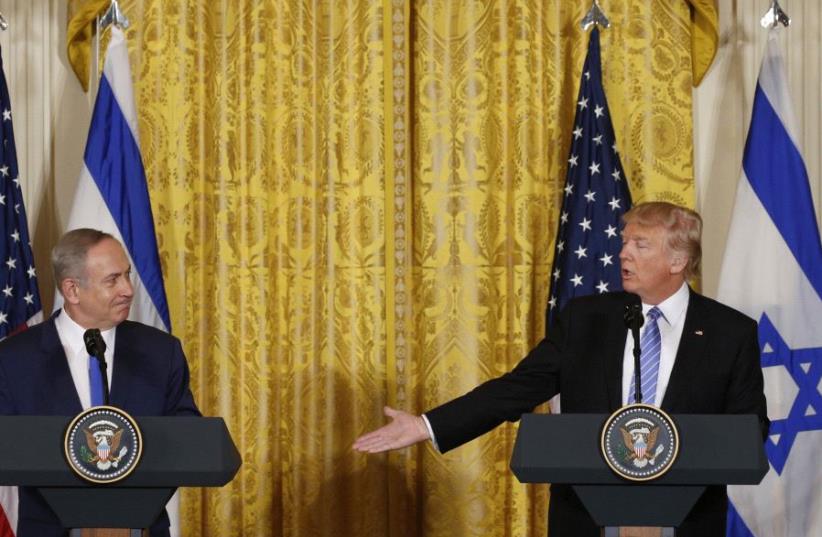US President Donald Trump (R) acknowledges Israeli Prime Minister Benjamin Netanyahu at a joint news conference at the White House. (photo credit: KEVIN LAMARQUE/REUTERS)