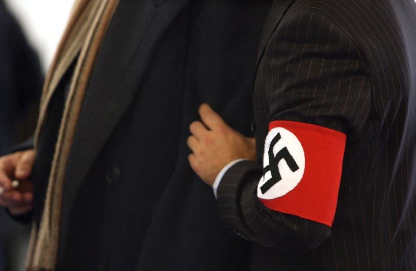 A man wears a costume with a swastika armband  (photo credit: REUTERS)