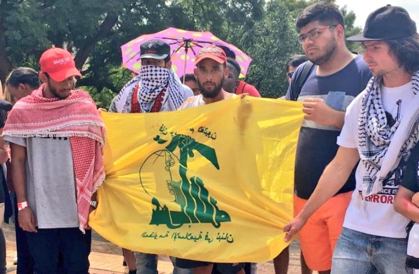 Students hold a Hezbollah flag during a demonstration at Wits University during 'Israeli Apartheid Week' (photo credit: SAUJS)