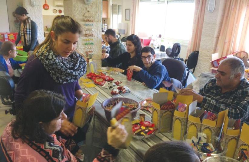 Residents and volunteers prepare some of the 1,500 Purim gifts for Migdal Ha’emek’s schoolchildren at the Grabski Center in the North yesterday (photo credit: Courtesy)