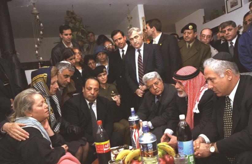 B. Netanyahou, entouré du roi de Jordanie, avec les proches des victimes (photo credit: GPO)