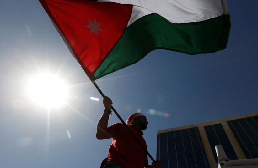 A Jordanian protester holds a Jordanian national flag (photo credit: REUTERS)