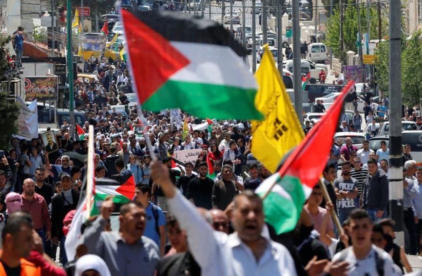 Palestinians take part in a protest in solidarity with Palestinian prisoners held by Israel, in the West Bank town of Bethlehem April 17, 2017 (photo credit: REUTERS/AMMAR AWAD)
