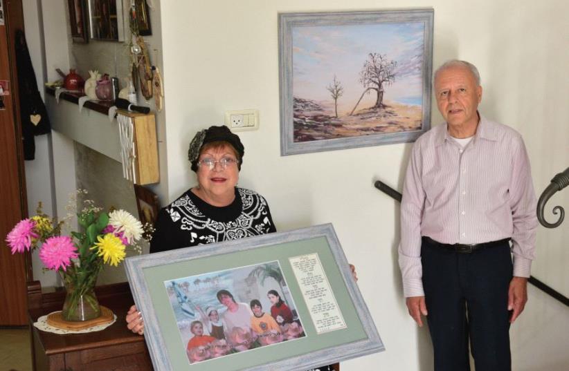 In their Ashkelon home, Suzy and Momi Malka show a picture of their daughter Tali and four granddaughters (photo credit: ZION BARON)