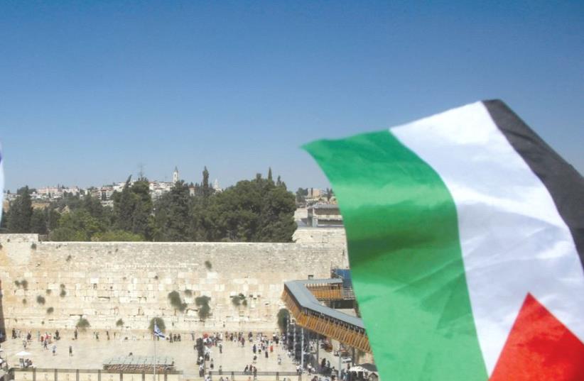 A Palestinian flag is seen waving in front of the Kotel (photo credit: REUTERS)