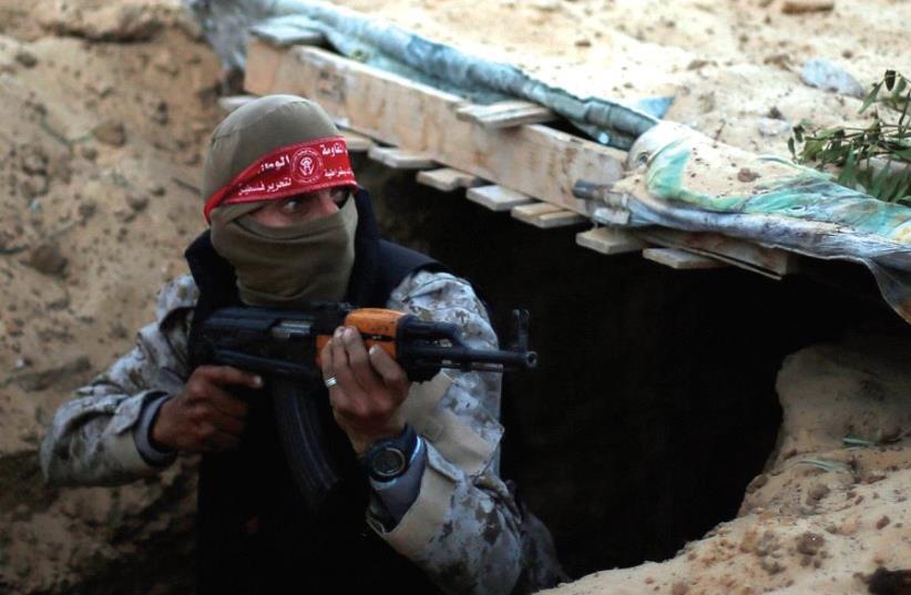 A Palestinian fighter takes part in a tunnel attack simulation during a graduation ceremony in Rafah, in the southern Gaza Strip, last November (photo credit: REUTERS)