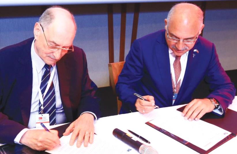 FEDERATION OF ISRAELI Chambers of Commerce board member Amnon Dotan (left) and Turkish Exporters Assembly chairman Mehmet Buyukeksi sign a memorandum of understanding for economic collaboration in Tel Aviv 16.5.2017.. (photo credit: Courtesy)