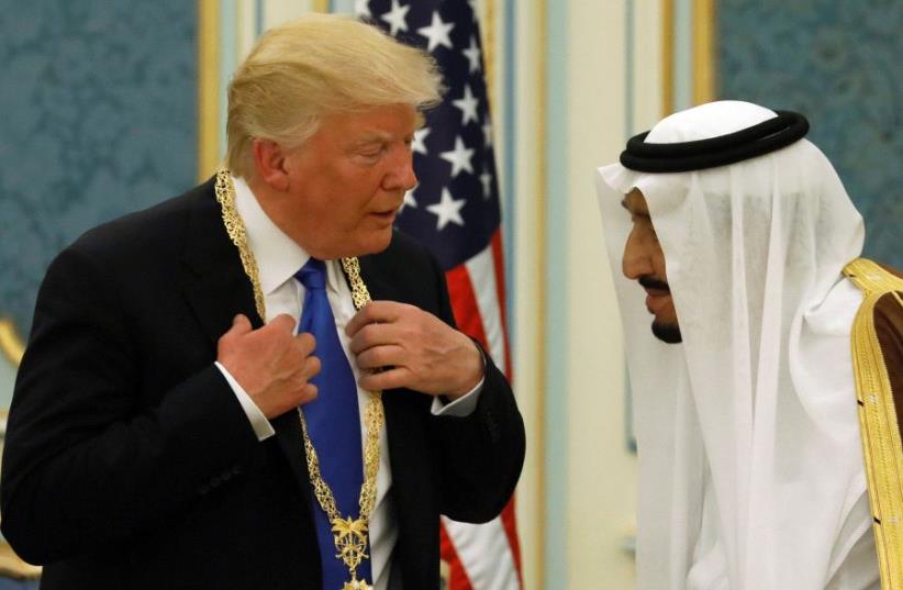 Saudi Arabia's King Salman bin Abdulaziz Al Saud (R) presents US President Donald Trump with the Collar of Abdulaziz Al Saud Medal at the Royal Court in Riyadh, Saudi Arabia (photo credit: JONATHAN ERNST / REUTERS)