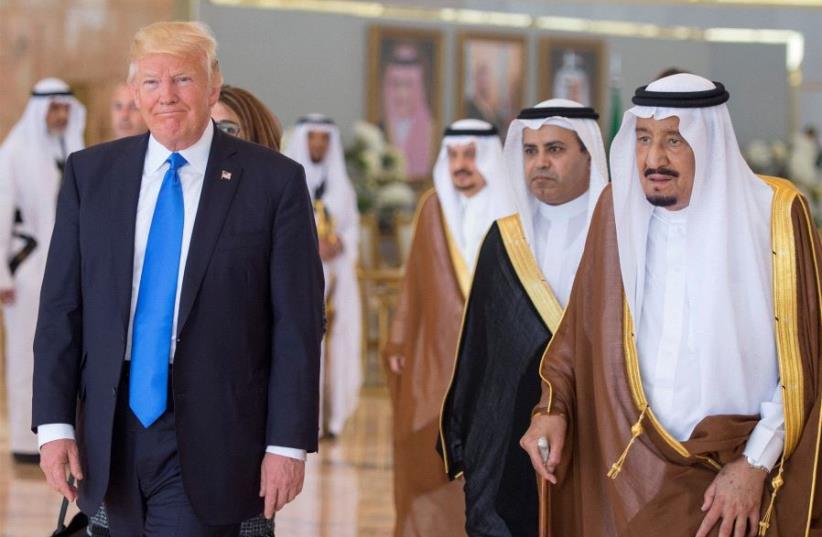 Saudi Arabia's King Salman bin Abdulaziz Al Saud walks with US President Donald Trump during a reception ceremony in Riyadh, Saudi Arabia, May 20, 2017 (photo credit: REUTERS)