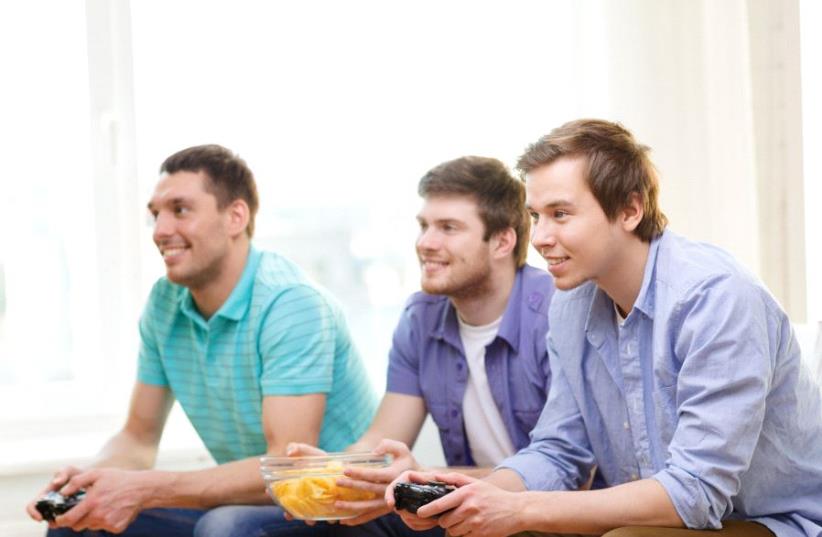 Young Americans playing video games (illlustrative) (photo credit: INGIMAGE)