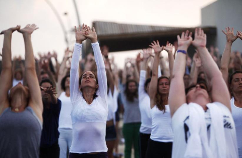 People practice yoga in Tel Aviv [File] (photo credit: REUTERS)
