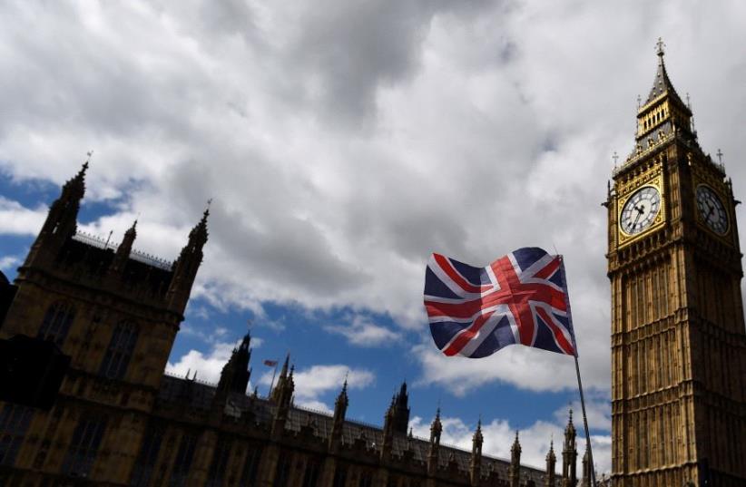 The Union Flag flies near the Houses of Parliament the day before a general election in central London, Britain June 7, 2017. (photo credit: REUTERS/CLODAGH KILCOYNE)