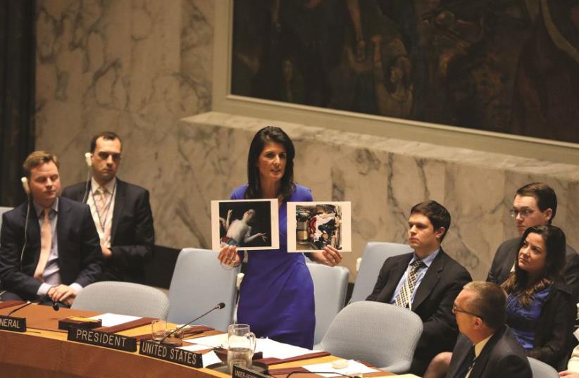 Nikki Haley montrant à l’ONU des photos  des victimes des armes chimiques d’Assad (photo credit: REUTERS)