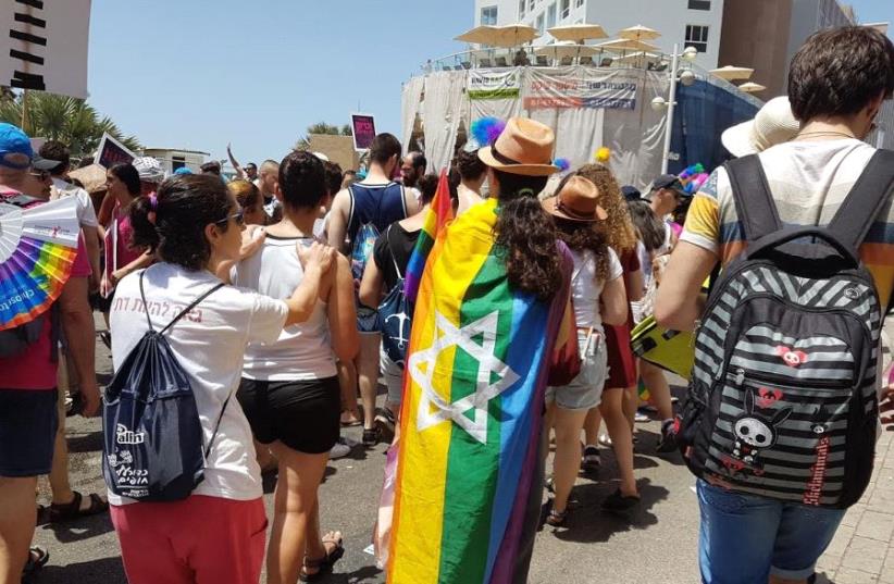Participant with Jewish Pride flag walking in the 2017 Tel Aviv Pride Parade (photo credit: BECKY BROTHMAN)