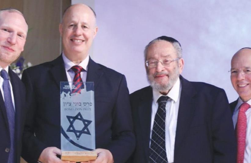 RABBI CHAIM BROVENDER (second right) looks to receive his award, accompanied by Regional Cooperation Minister Tzachi Hanegbi (center) and Nefesh B’Nefesh cofounders Rabbi Yehoshua Fass (left) and Tony Gelbart. (photo credit: KNESSET)