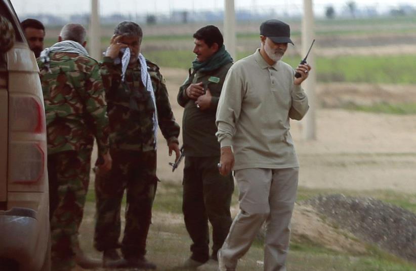Qassem Soleimani uses a walkie-talkie on the frontline during offensive operations against Islamic State militants in the town of Tal Ksaiba, in Salahuddin province, in 2015 (photo credit: REUTERS)
