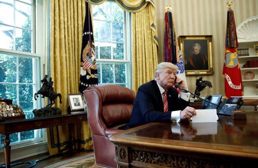 US President Donald Trump during a phone call at the Oval Office of the White House in Washington, U.S., June 27, 2017. (photo credit: REUTERS/CARLOS BARRIA)