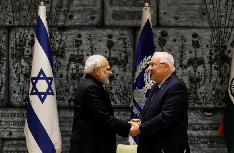 Indian Prime Minister Narendra Modi shakes hands with President Reuven Rivlin after signing a guest book before their meeting in Jerusalem July 5, 2017 (photo credit: REUTERS)