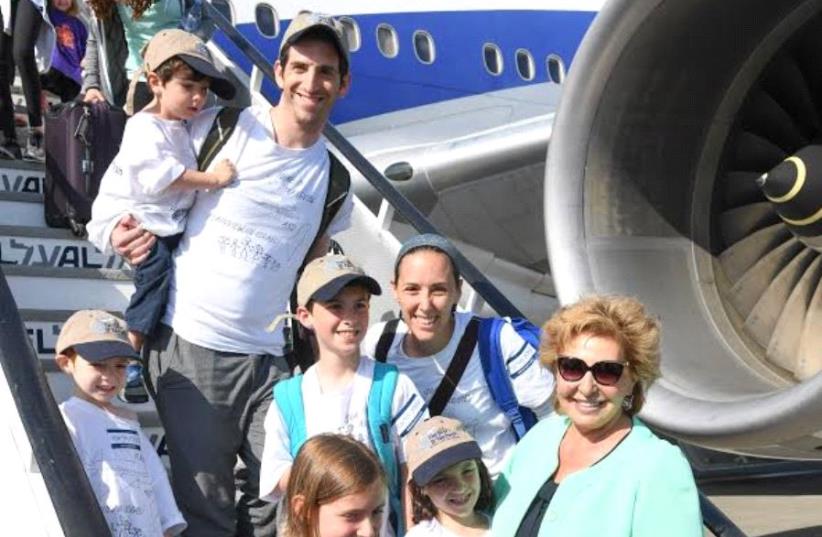The Bienenfeld family from Plainview, NY getting off the plane in Tel Aviv with Minister of Aliyah and Integration Sofa Landver. (photo credit: SHAHAR AZRAN COURTESY OF NEFESH B’NEFESH)