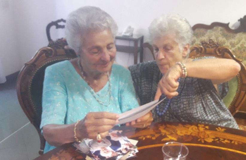 PROF. ALESSANDRA STADERINI (right), daughter of Fausto and Bice who sheltered their Jewish friends’ children Bianca Campagnano (left) and her brother in their home in Rome during the Nazi occupation of Italy. The two women look through family photos at LUMSA University in Rome on June 27 (photo credit: TAMARA ZIEVE)