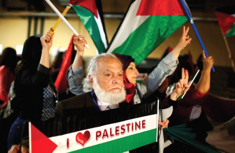 PEOPLE HOLD Palestinian flags during the Conference of Palestinians in Berlin in 2015. (photo credit: REUTERS)