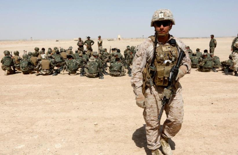A US Marine walks near Afghan National Army (ANA) soldiers during training in Helmand province, Afghanistan, July 5, 2017. (photo credit: REUTERS/OMAR SOBHANI)
