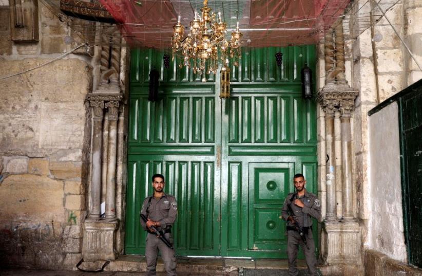 Israeli border policemen secure the entrance to the compound known to Jews as Temple Mount, in Jerusalem's Old City July 14, 2017. (photo credit: REUTERS/AMMAR AWAD)