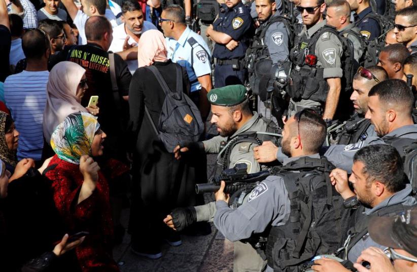 A Palestinian woman argues with an Israeli border policeman at the entrance to the compound known to Muslims as Noble Sanctuary and to Jews as Temple Mount, in Jerusalem's Old City  (photo credit: AMMAR AWAD / REUTERS)