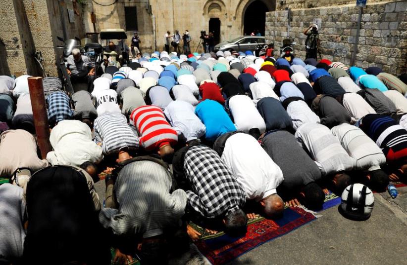 Palestinian men pray outside the Temple Mount after Israel removed the new security measures there, in Jerusalem's Old City July 25, 2017.  (photo credit: REUTERS)
