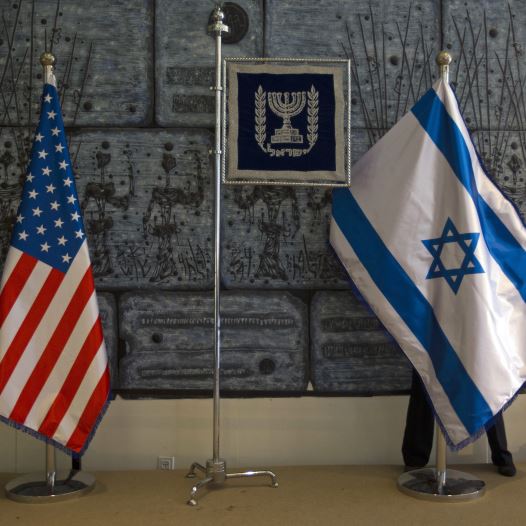 An employee arranges an Israeli national flag next to a U.S. one