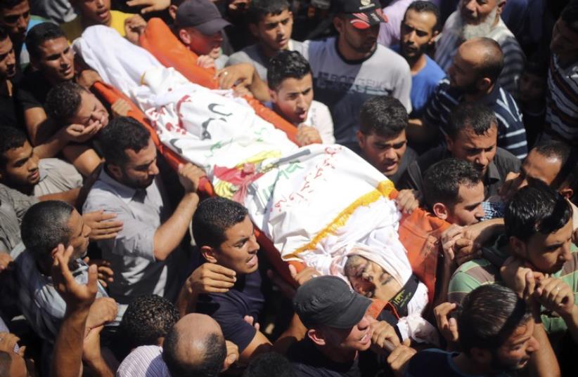 Palestinians carry body of senior local leader of the Islamic Jihad militant group Hafez Hamad during his funeral in the town of Beit Hanoun in the northern Gaza Strip (photo credit: REUTERS)