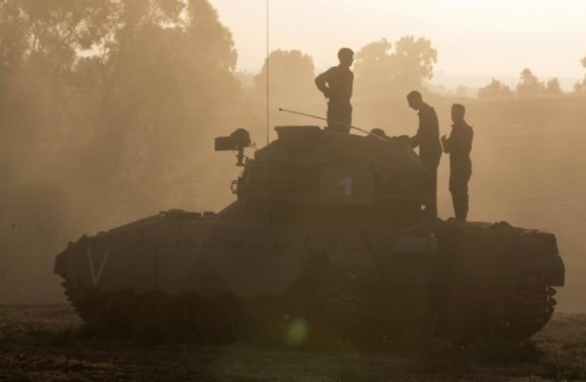 Israeli soldiers stand atop an APC outside the central Gaza Strip (photo credit: REUTERS)