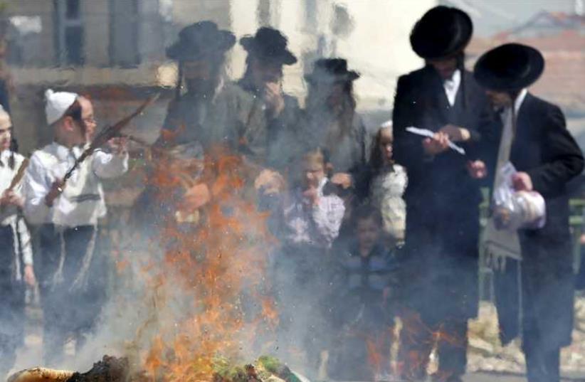 Ultra-Orthodox men burn leaven in Jerusalem ahead of Passover, April 3, 2015 (photo credit: REUTERS)